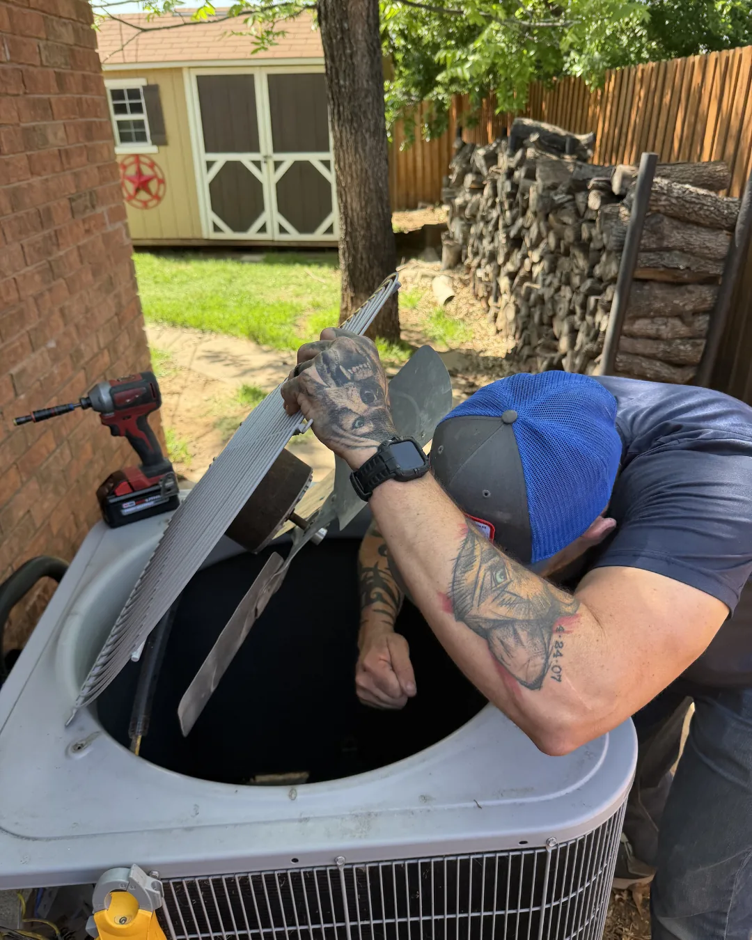 Hawkins technician repairing an outdoor AC condenser in an Abilene backyard
